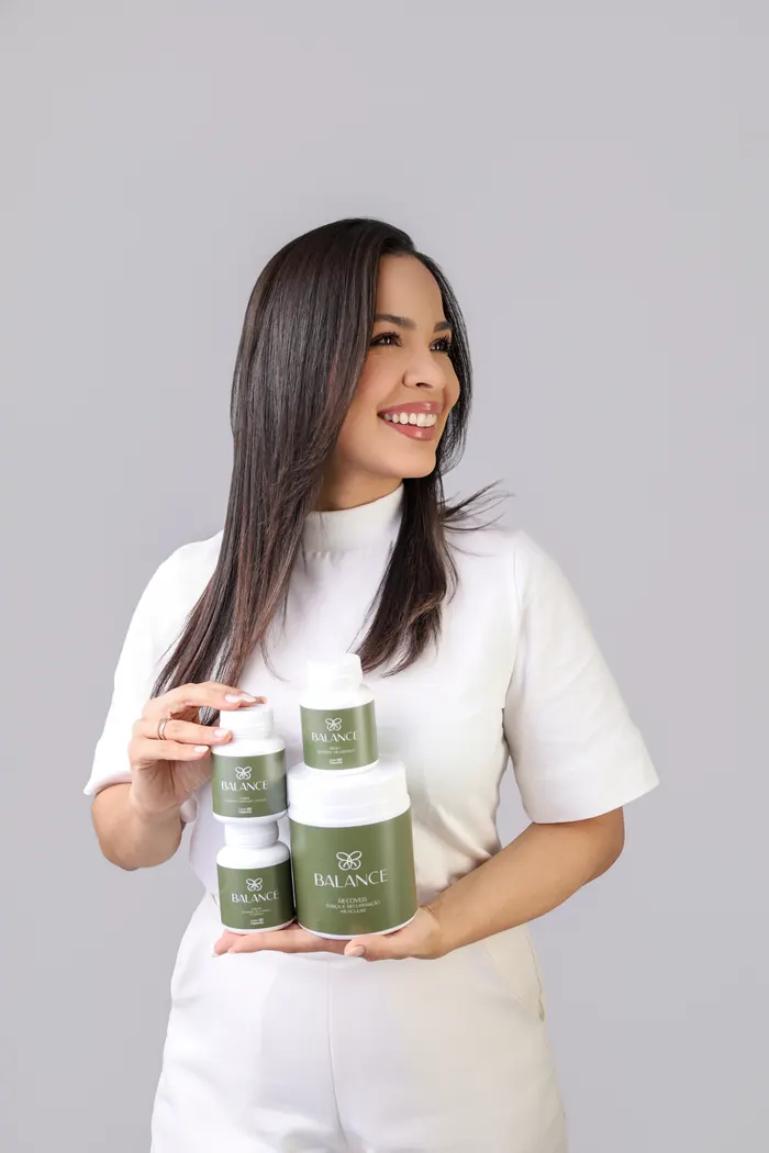 Laura Ramalho segurando os quatro produtos da linha Balance