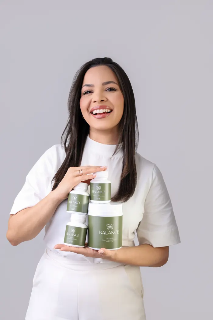 Laura Ramalho sorrindo com os potes da linha Balance